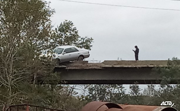 Седан снес бордюр и повис на мосту в Южно-Сахалинске