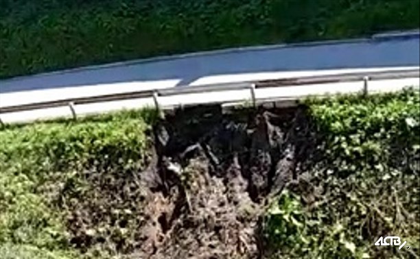Вода с разрушенной дороги в Корсакове вновь течет под жилые дома