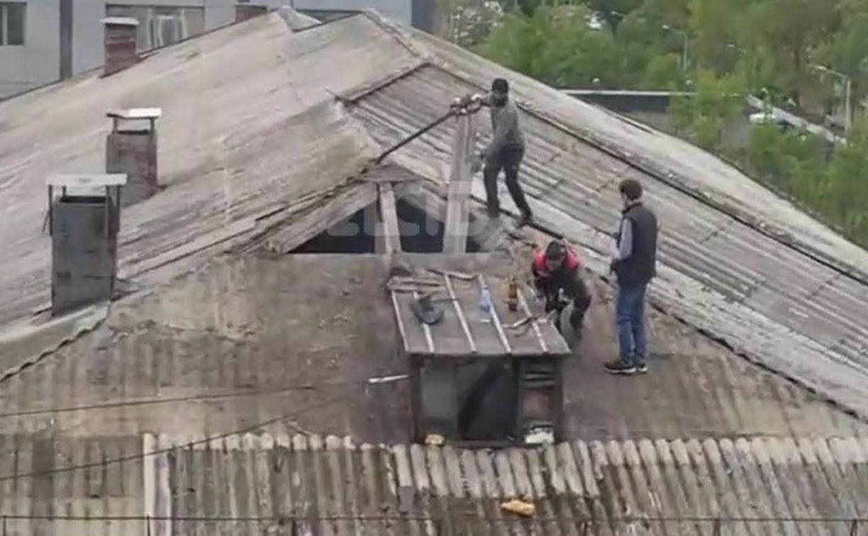 Бесстрашные рабочие карабкались по крыше четырёхэтажки в Южно-Сахалинске