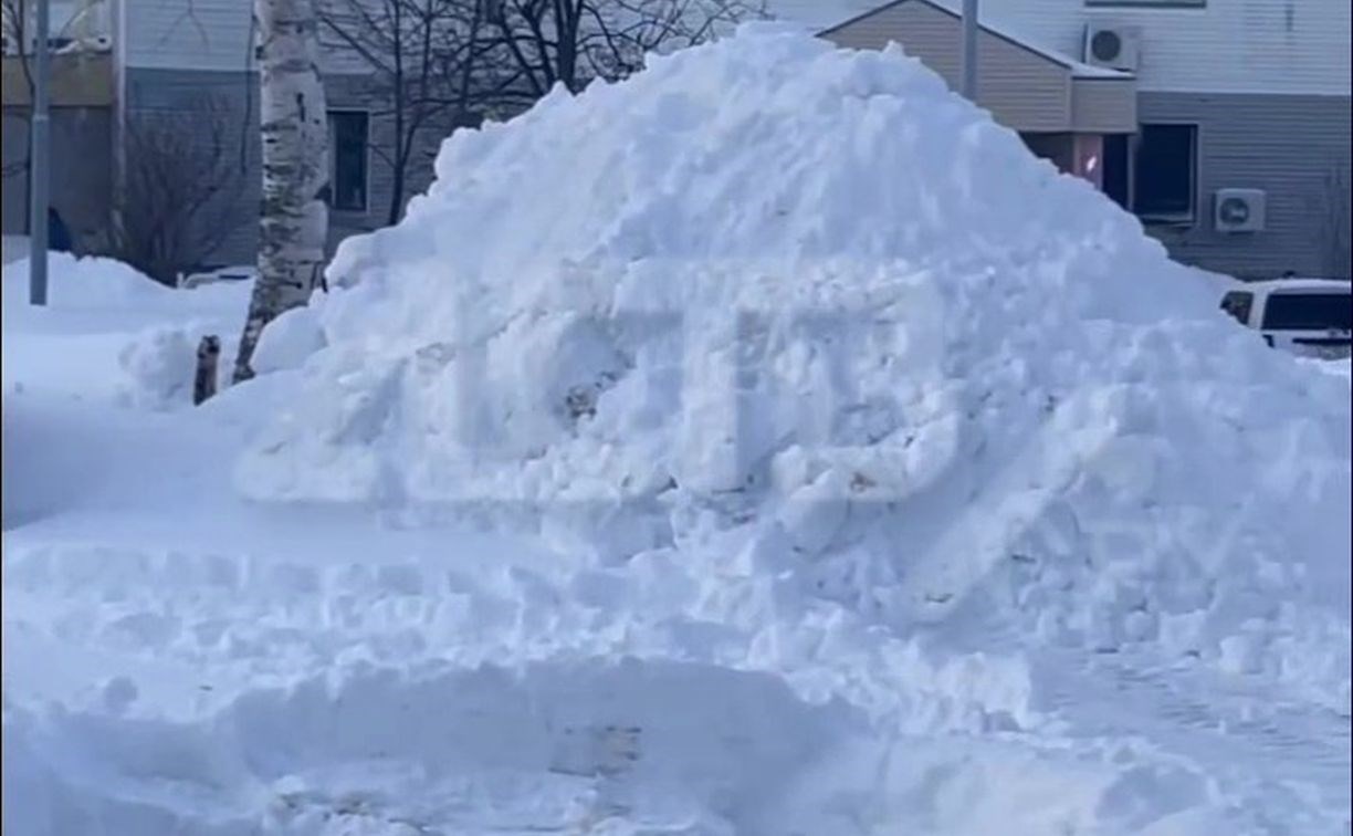 Побитый в ДТП автомобиль завалили кучей снега в Южно-Сахалинске - очевидец
