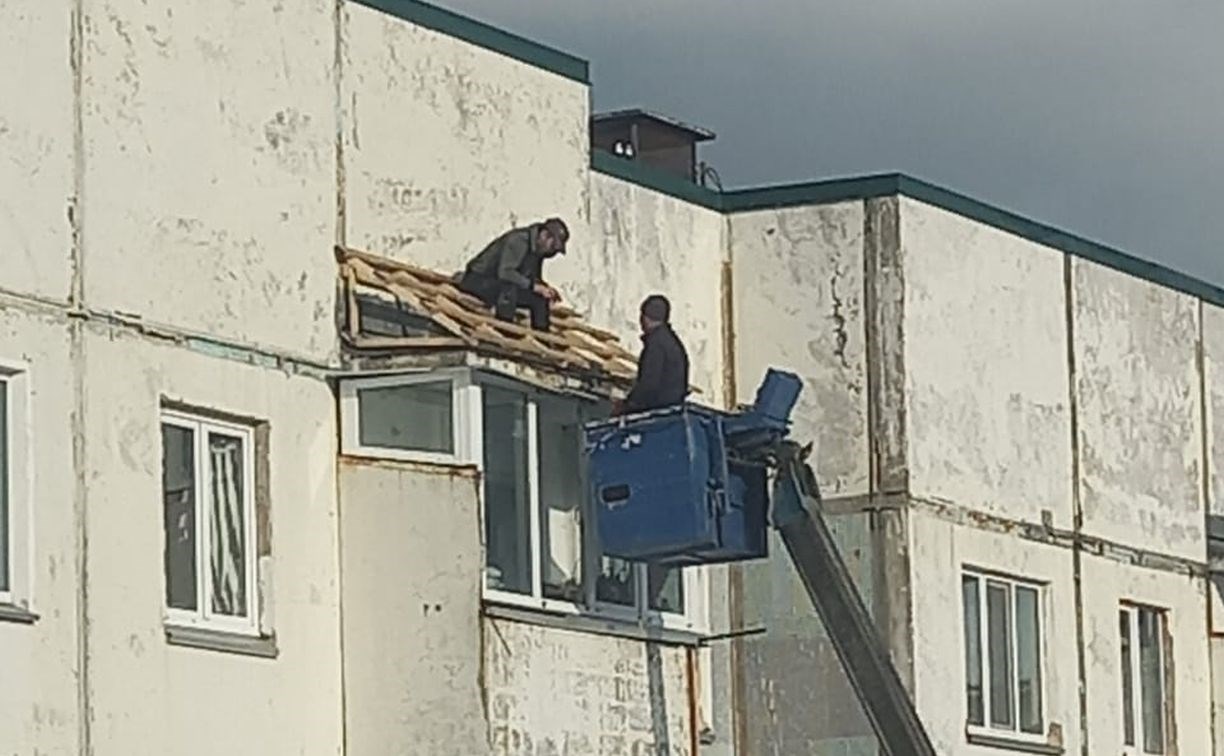 "Как он держится?": в Южно-Сахалинске рабочий без страховки чинит крышу балкона на пятом этаже