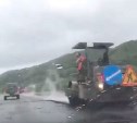 В Холмске дорожники укладывают асфальт в дождь 