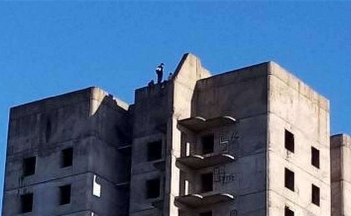 От снимка веет ужасом: подростки устроили опасные игры на крыше 12-этажного недостроя в Холмске