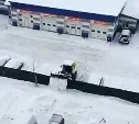 Снег через забор: владельцы стоянки в Луговом с выдумкой подошли к расчистке территории 