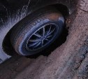 Колесо автомобиля провалилось в 50-сантиметровую яму в Южно-Сахалинске