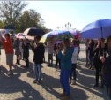 С зонтиками в солнечный день вышли школьники на площадь в Южно-Сахалинске
