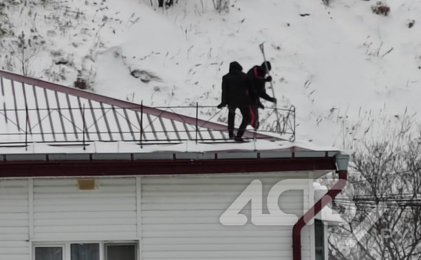 "Видно, что сами боялись": рабочие без страховки расчищали крышу четырёхэтажки в Невельске