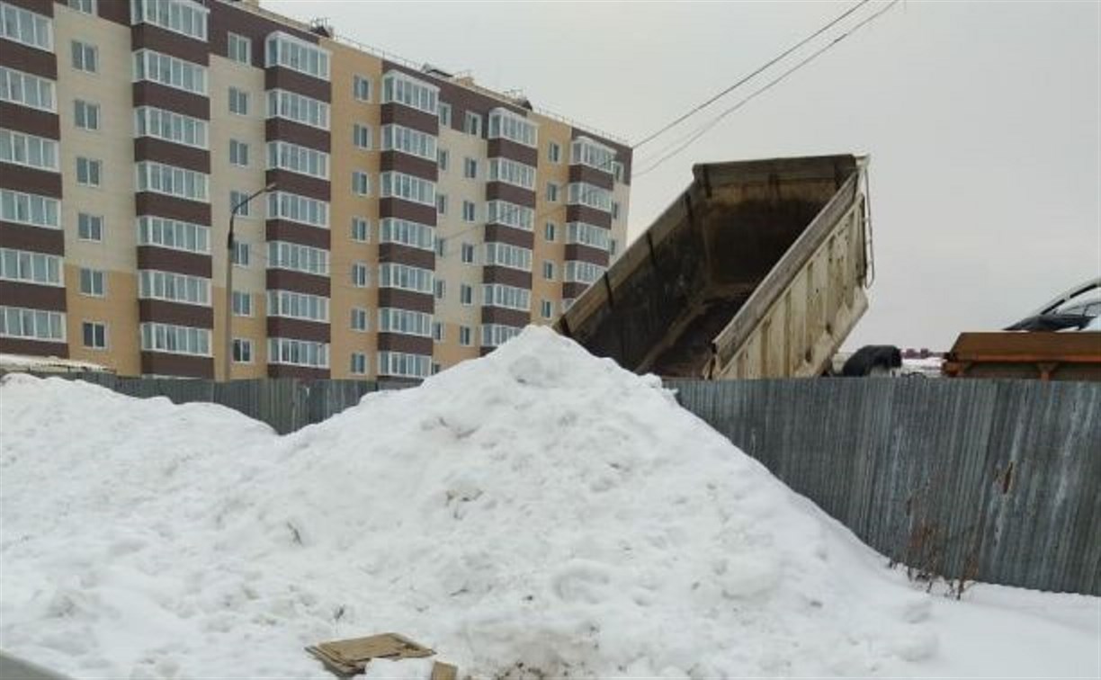 В Луговом снегом со стоянки завалили открытый люк, где в сугробах играют дети