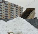 В Луговом снегом со стоянки завалили открытый люк, где в сугробах играют дети