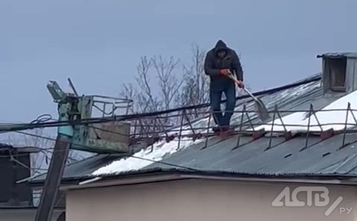Южносахалинцы второй день наблюдают, как по крыше пятиэтажки опасно ходит человек с лопатой