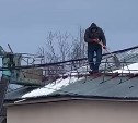 Южносахалинцы второй день наблюдают, как по крыше пятиэтажки опасно ходит человек с лопатой