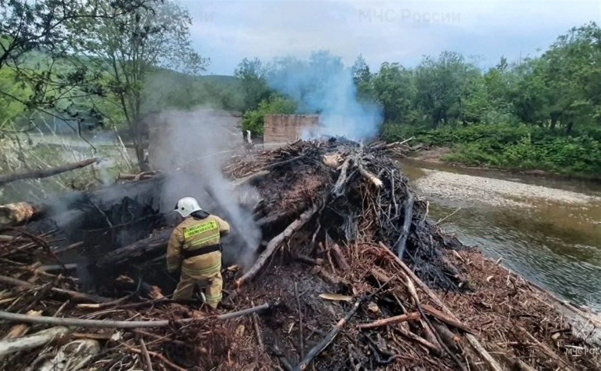 В Томаринском районе загорелся затор из брёвен на реке