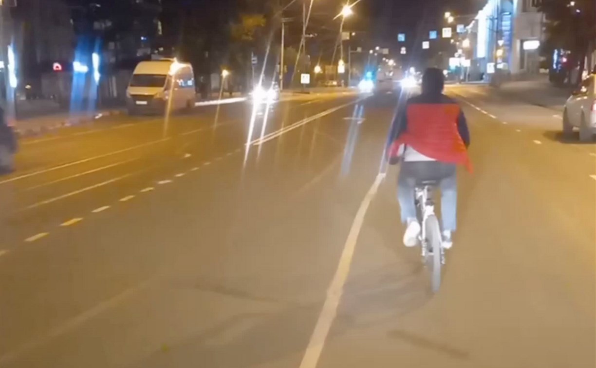 Уверенный в себе велосипедист неспеша ехал по центру дороги в Южно-Сахалинске