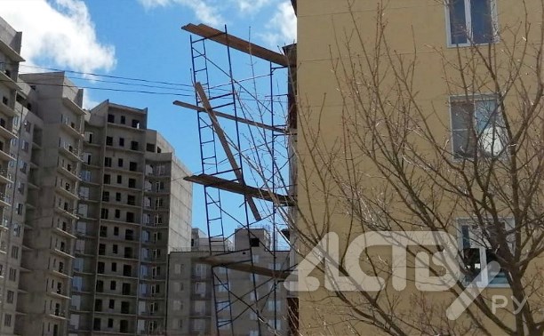 Сильный ветер в Южно-Сахалинске сорвал строительные леса с дома