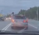 Молодой человек в Южно-Сахалинске наполовину вылез из окна движущегося авто и размахивал руками