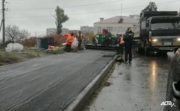 Холмские дорожники укладывают асфальт в дождь