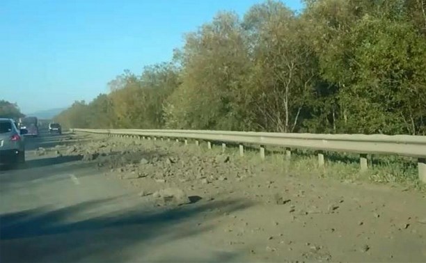 Рассыпанный по дороге грунт с камнями затрудняет движение автомобилей по Анивской трассе