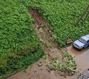 "Оползень сошел": насыпь под новой парковкой в Корсакове в дождь утекла в соседний двор