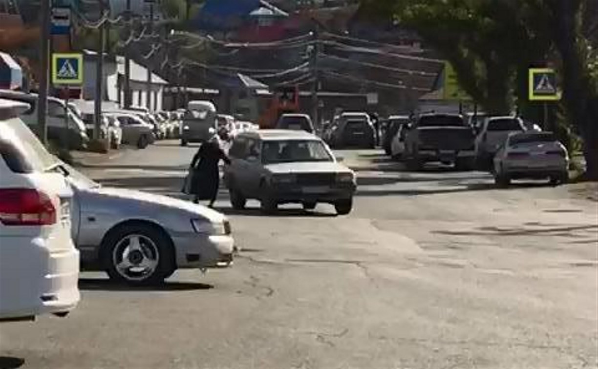 Женщина с бюстгальтером бросается под колеса автомобилей в Холмске