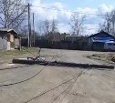 В поселке Тымовского района на дорогу массово повалились столбы связи