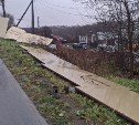Новый забор повалило ветром на тротуар в Корсакове