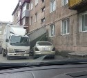 Грузовик снес козырек и дверь в подъезде многоэтажки в Южно-Сахалинске