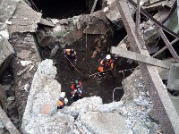 В Поронайске спасатели разбивают плиту, под которой находится погибший рабочий, Фото: 2
