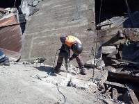 В Поронайске спасатели разбивают плиту, под которой находится погибший рабочий, Фото: 8